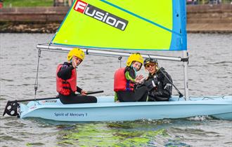 Two children and instructor in a dinghy on the water, UKSA event, what's on, children's activity, watersports, Easter event, Cowes, Isle of Wight