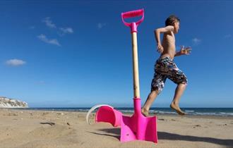 Boy next to bucket and spade on Yaverland Beach, Sandown, Isle of Wight, Things to Do