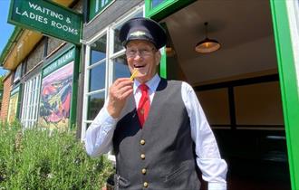 Conductor eating a chip at the Fish and Chip Evenings at Isle of Wight Steam Railway, Wootton, summer event