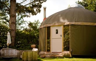 Outside view of yurt with outside seating at The Garlic Farm, Isle of Wight, unique place to stay