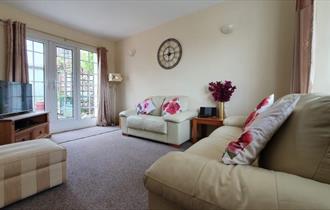 Lounge with french doors opening onto the patio in the garden at West View Holiday Cottage, Ryde, Self-catering