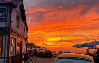 Outside view of The Old Fort with a sunset over the sea, Seaview, Isle of Wight, food & drink