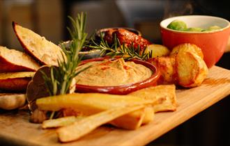 Festive tapas food on a wooden board at The Garlic Farm Restaurant, Christmas event, food and drink