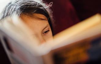 Child reading a book, book event at Quarr Abbey, Ryde, Isle of Wight, family event, what's on, children's activities