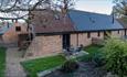 Outside view of Ash barn with outside dining area in garden, Fernhill Barns, Wootton, Isle of Wight, self-catering