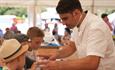 Chris Bevin helping children cook in the Little Chefs Den at at The Great Wight Bite, food and drink festival, Cowes, Isle of Wight, event, what's on