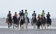Group of people riding horses on the beach, Fairfields Farm Riding School, Ryde, Isle of Wight, children's activities, family fun, adventure rides