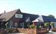 Outside view of The Fighting Cocks with outside seating area, Arreton, pub