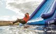 Lady going down the slide at Isle of Wight Aqua Park, Tapnell Farm, watersports, outdoor activities