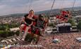 People riding the high swing ride over the crowds at the Isle of Wight Festival, music event, what's on
