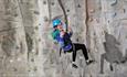 Isle of Wight, Activity, Rock Climbing, Sandown Rocks, young person dangling at height from climbing wall giving thumbs up.