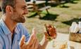 Man eating a burger at The Cow Restaurant, Food & Drink, Tapnell Farm Park, Isle of Wight