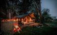 Exterior view of Safari Tent with hot tub with lights at night, Tom's Eco Lodge, Tapnell Farm Holiday Destination, self-catering, West Wight, Isle of
