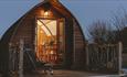 Exterior view of Eco Pod with lights at night, Tom's Eco Lodge, Tapnell Farm Holiday Destination, self-catering, West Wight, Isle of Wight