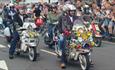 Isle of Wight Scooter Rally, image of Scooter Riders riding along road with onlookers applauding