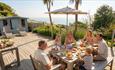 Family eating outside on terrace with sea in the background at Gills Cliff House in Ventnor on the Isle of Wight, self catering