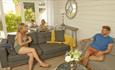 Family enjoying open plan living and dining area of self catering cottage at The Bay Colwell Holiday Resort, Isle of Wight