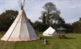 Outside view of tipi with a bell tent and picnic bench next door, Isle of Wight Tipi Holidays, glamping