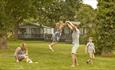 Family playing outside on green area at St Helens Holiday Resort, Isle of Wight, Self Catering