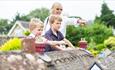 Family stood next to the thatched cottages at the Godshill Model Village, Isle of Wight, Things to Do