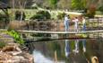 Children walking along the bridge across the pond at Robin Hill Adventure Park, Newport, Isle of Wight, attraction, family, children activities