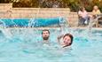 Couple splashing in the swimming pool at St Helens Holiday Resort, Isle of Wight, Holiday Park