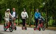 Group of people hiring electric bikes and electric scooters from Voi, getting around, Isle of Wight, bike hire, cycling