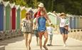 Family walking along Colwell beach esplanade near The Bay Colwell Holiday Resort, Isle of Wight, Self Catering