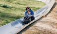 Mum and son riding on the toboggan at Robin Hill Adventure Park, attraction, Isle of Wight, family fun, things to do