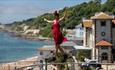 Lady walking along a tightrope with the sea in the background in Ventnor on the Isle of Wight