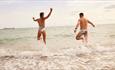 Two people running in to the sea, Joyride Festival, Isle of Wight, cycling, wellness, health & wellbeing, food, music, what's on, event