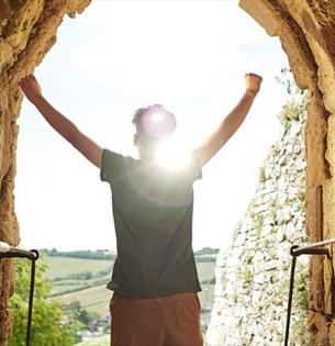 Man standing in arch of Carisbrooke Castle looking at the view, historic attraction, family fun, children's activities, summer event, what's on, Isle