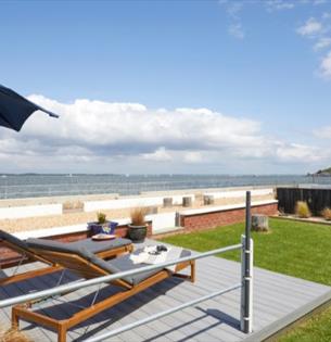 Outside loungers with umbrella facing a sea view at Sea Lights, Classic Cottages, Isle of Wight, self catering, accommodation