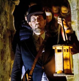 Man with a lantern exploring Carisbrooke Castle in the dark, Halloween event, what's on, Isle of Wight