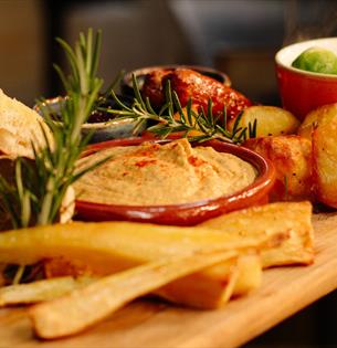 Festive tapas food on a wooden board at The Garlic Farm Restaurant, Christmas event, food and drink