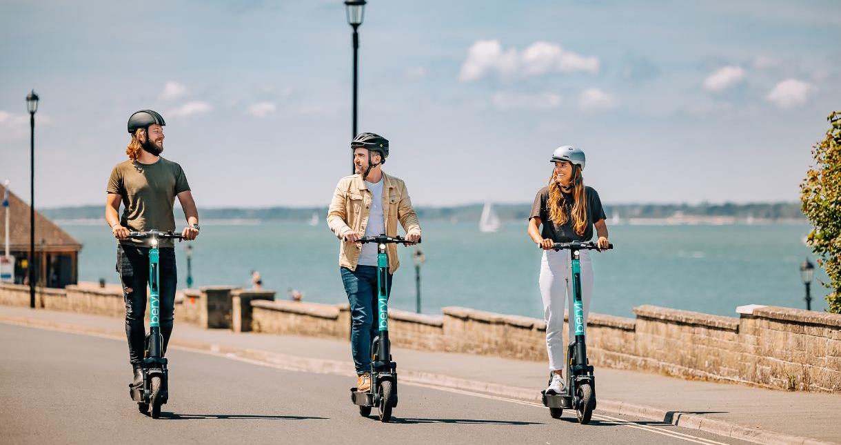 Adults riding Beryl scooters in Cowes, Isle of Wight
