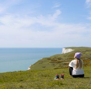 Walker sitting on a cliff overlooking the sea on the Isle of Wight