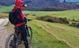 Cyclist stopping to take the view of the rolling countryside on the Isle of Wight, cycling tour, activity