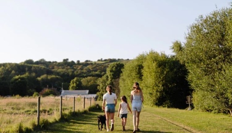 Isle of Wight, Things to Do, Easter Event, Garlic Farm Trail, Image of three people walking away with black dog.