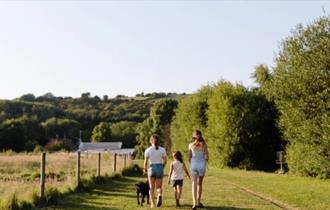 Isle of Wight, Things to Do, Easter Event, Garlic Farm Trail, Image of three people walking away with black dog.