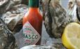 Oysters with lemon and bottle of Tabasco sauce at The Coast Bar & Dining Room, Cowes, Eat & Drink