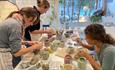 Isle of Wight, Things to do, Isle of Wight Pottery, Niton, Crafting/Decorating table with 3 people decorating pottery.