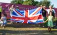 Family holding a flag at The Wight Proms, what's on, event, Cowes, Isle of Wight