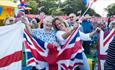 Group of people enjoying the music and waving flags, The Wight Proms, what's on, event, Cowes, Isle of Wight