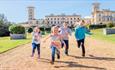 Children running with Osborne House in background, Osborne, attraction, things to do, East Cowes, Isle of Wight