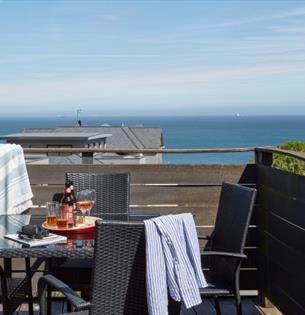 Outside dining table and chairs on balcony with sea views at Shanklin Villa Aparthotel, Isle of Wight, Self catering