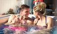 Couple in hot tub at The Bay Colwell Holiday Resort, Isle of Wight, Self Catering