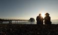 Couple watching the sunset at Totland Bay, Isle of Wight - copyright: visitisleofwight.co.uk
