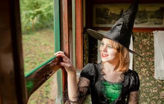Isle of Wight, Things to Do, Isle of Wight Steam Railway, Wizard Week, Image of lady in witch costume looking out of carriage window.