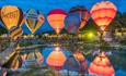 Hot air balloons glowing in the dark across the lake at Isle of Wight Balloon Festival, Robin Hill, what's on, events